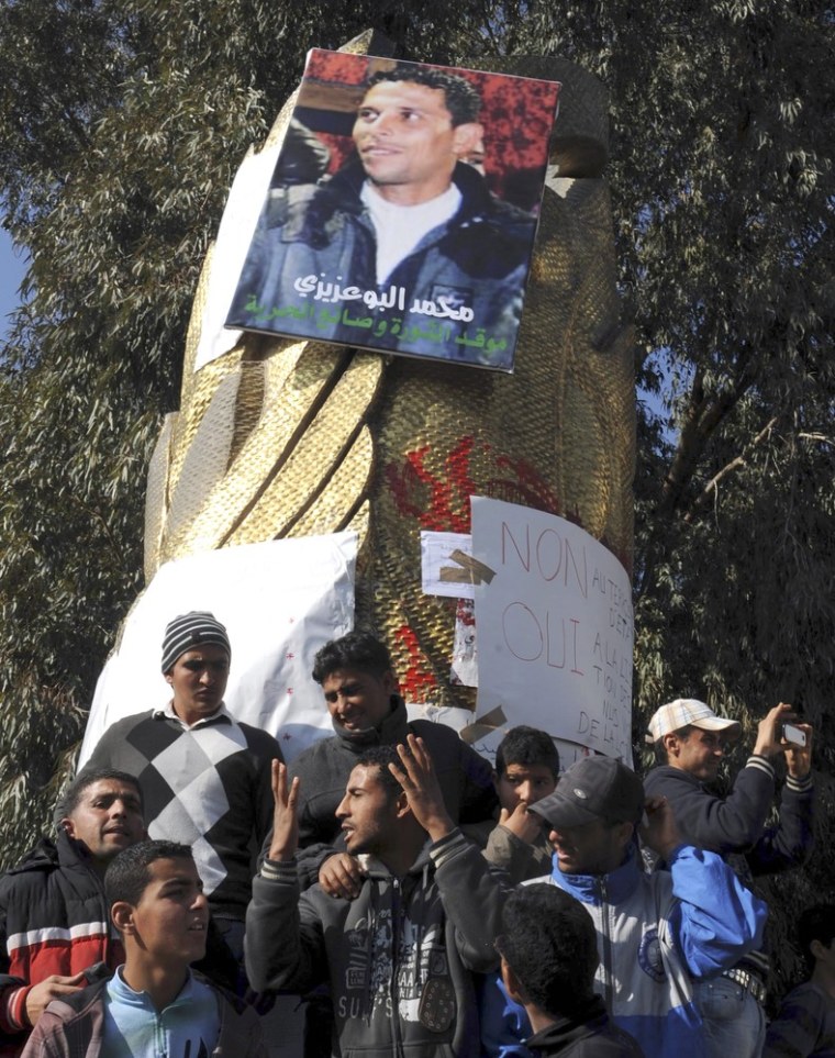 Image:  Youths gather at a portrait of Mohamed Bouazizi